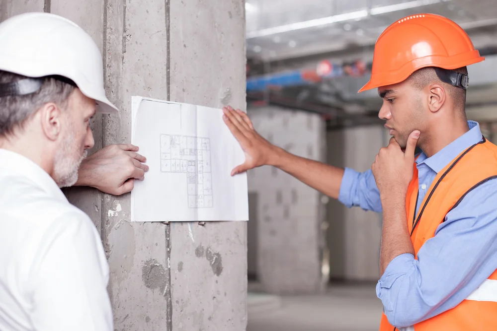 Zwei Abrissarbeiter besprechen Abrissvorgang