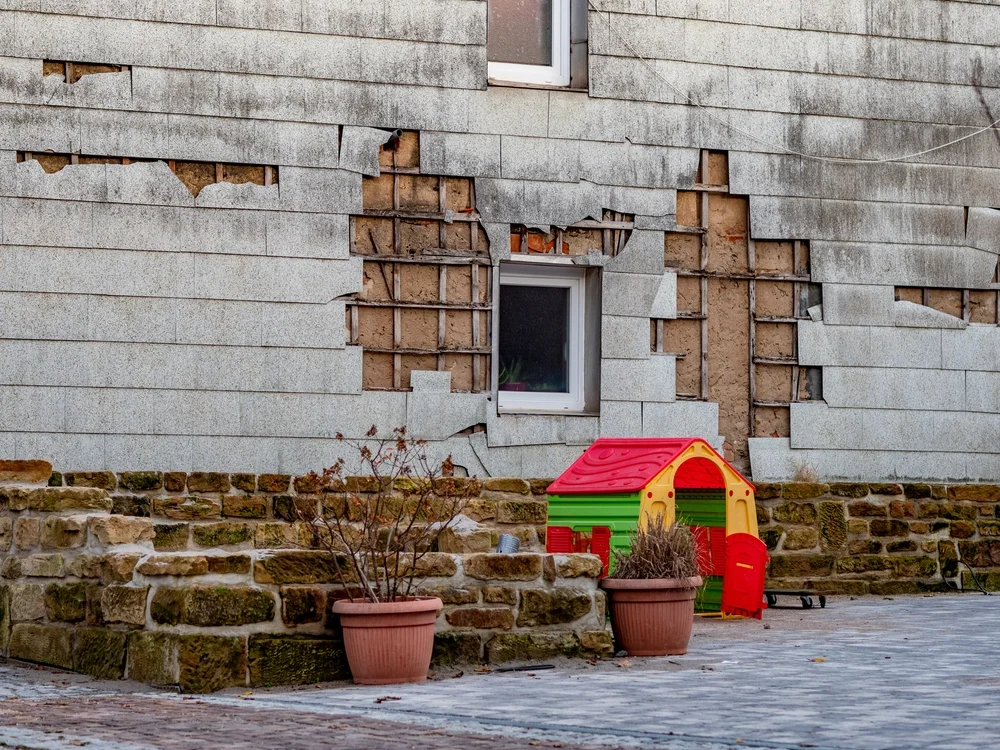 Alte beschädigte Asbestwand-Wandverkleidung